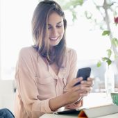 Smiling businesswoman checking cell phone