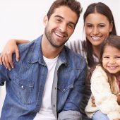 Portrait of a happy young family sitting together at home